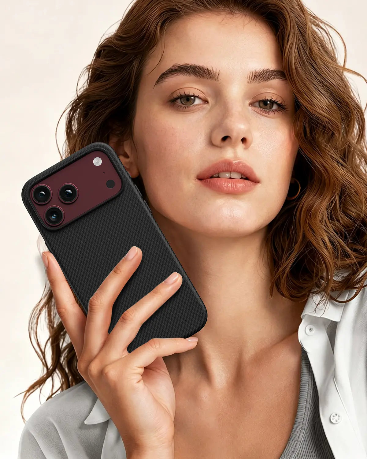 Woman holding an iPhone 18 Pro fitted with a NOX Carbon Black aramid fiber protective case, showcasing daily slim style and secure grip.