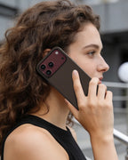 Woman holding an iPhone 18 Pro Max with NOX Sunset Copper aramid fiber case, showing sleek tactile grip and executive style.